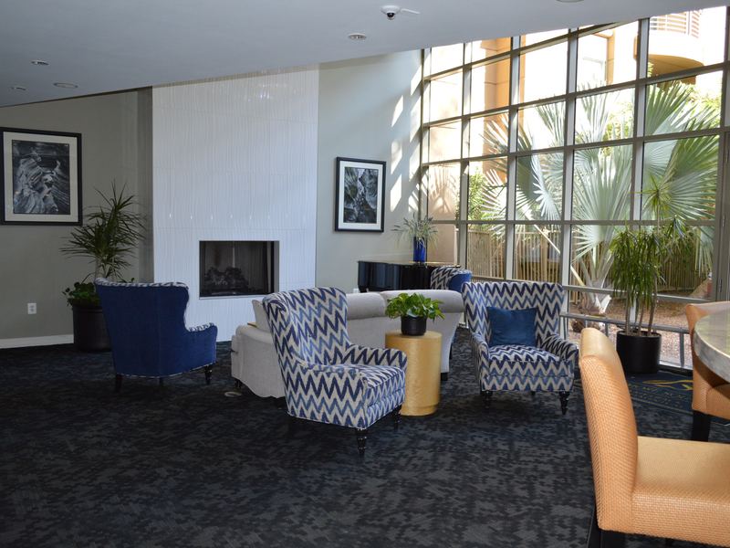 Clubhouse lounge seating around a fireplace, with a piano nearby