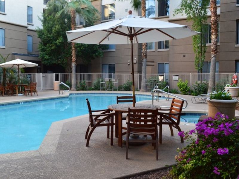 Poolside umbrella table seating near bougainvillea